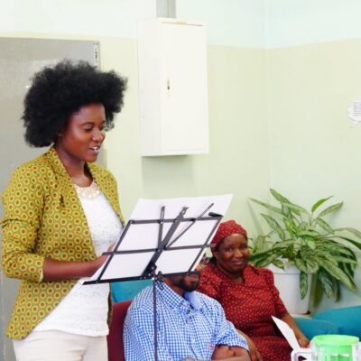 poet TJ Dema reads in front of a podium at the Botswana library